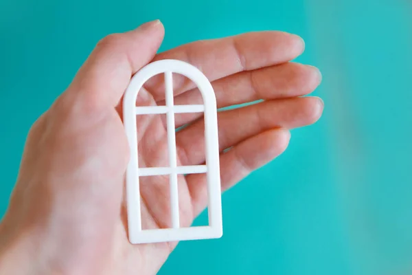 plastic window in hand close-up on a blue background. Advertising of accessories, installation, cleaning