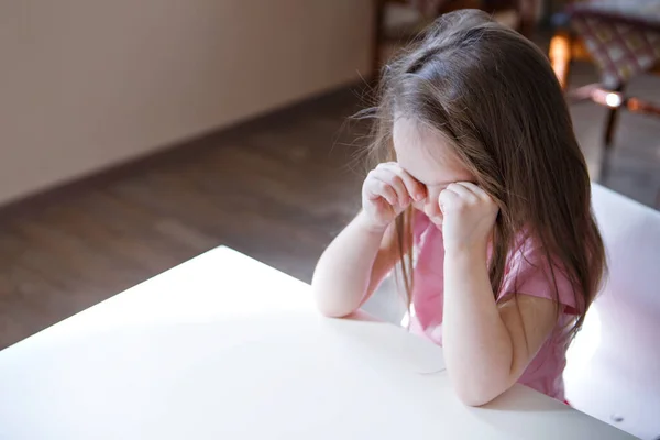 Çocuk sıkıldı, üzgün surat. Kız ağIıyor. Çocukluk konsepti, çocuk günü, anaokulu telif alanı, kötü ruh hali, ev hapsi, itaatsizlik, ebeveynlik, üzüntü, duygular.