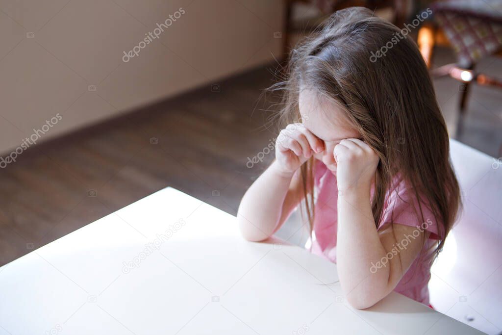 the child is bored, sad face. The girl is crying. The concept of childhood, children's day, kindergarten copyspace, bad mood, house arrest, disobedience, parenting, upset, emotions