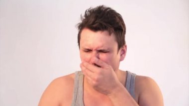 Beyaz arka planda tıbbi maske takan bir adamın portresi. Tıbbi ekipmanların tanıtımı. Adam işaret ediyor. Karantina, kendini izole etme, koronavirüsten koruma, virüs, hastalık korkusu, tedavi, ilaç