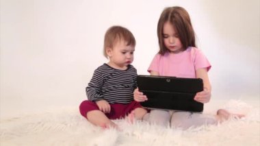 Çocuklar tablette çizgi film izliyorlar. Aile zamanı, tatil. Ev ödevi, karantina, kendini izole etme, koronavirüsten koruma, virüs, ev eğitimi, mesafe çalışması, eğitim