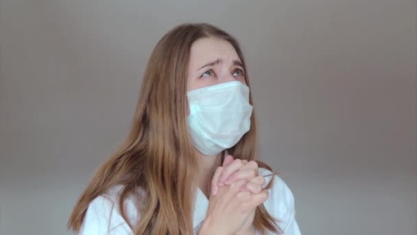 Een Meisje Met Een Medisch Masker Bidt Met Gevouwen Handen — Stockvideo