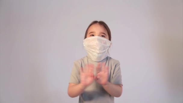 一个戴着医疗面具 背景为白色的孩子的画像 医疗设备示范 女孩得分了 自我隔离 防止头孢病毒 害怕疾病 药物的概念 — 图库视频影像