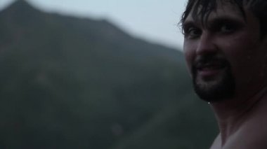 Islak bir adamın portresi. Damlalar yüzüme damlıyor. Sıkı çalışmadan sonra mutlu bir insan. Güç egzersizleri, kilo verme, bronzlaşma, yüzme, banyo sonrası vücut buharı, yorgunluk.