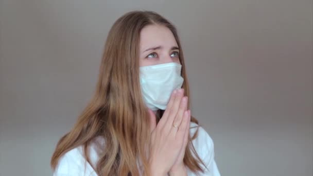 Een Meisje Met Een Medisch Masker Bidt Met Gevouwen Handen — Stockvideo