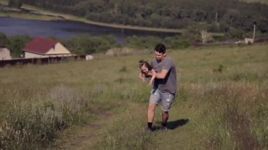 Baba kızıyla çayırda yürüyor. Adam çocuğu fırlatıyor. Bebek uçuyor. Köy evleri, orman ve nehir arka planda. Yaz mevsimi, sıcaklık, özgürlük, köy hayatı, güneş yanığı, aile günü