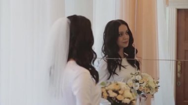 Gelin gelinliği dener. Kız, aynadaki yansımasına hayran. Düğün moda konsepti, aile günü, sevgililer günü.