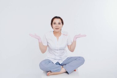 Lastik eldivenli doktor ellerini kaldırdı. Kız salgın sırasında koruyucu ekipman takıyor. Bağış eylemi. Beyaz arka planda antiseptikler ve tıbbi ekipmanlar. Selamlaşmanın taklidi. Boşluğu kopyala