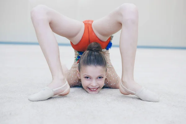 Eşofmanlı bir kız esneme hareketi yapar. Jimnastikçi spora gider. Sağlıklı yaşam tarzı konsepti, spor üniformaları, dünya kupası, spor salonu, özel kıyafetler, üniformalar.