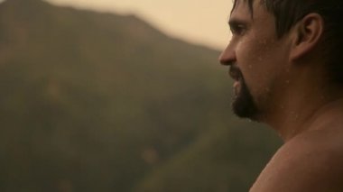 Islak bir adamın portresi. Damlalar yüzüme damlıyor. Sıkı çalışmadan sonra mutlu bir insan. Güç egzersizleri, kilo verme, bronzlaşma, yüzme, banyo sonrası vücut buharı, yorgunluk.