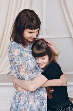 Şöminenin yanında ısınıyor ve dinleniyor. Anne-kız kucaklaşması. Aile kavramı, annelik, içsel, ev, çocukluk, anneler günü, çocuklar günü