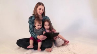 Bir anne, çocuklarına tabletteki çizgi filmleri gösterir. Aile zamanı, eğlence. Ev ödevi, karantina, kendini izole etme, koronavirüsten koruma, virüs, ev eğitimi, mesafe çalışması, eğitim