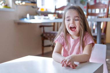 Ağızları açık küçük bir kız. Çocuk oyun oynuyor. Eğitim konsepti, çocukluk, duygular, dişçilik, sürpriz, arkadaşlık. Boşluğu kopyala
