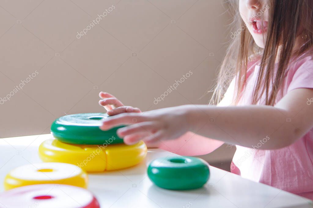 the child collects a pyramid. Details of the toy in the hands. Concept of development of fine motor skills, educational games, childhood, IVF, children's day, kindergarten copy space