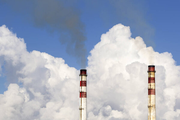 Industrial chimney against cloudy sky