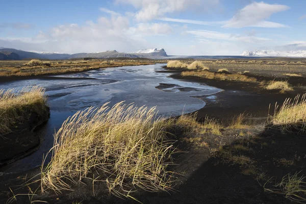 Podzimní krajina na Islandu s řeka, černým pískem a suché gra — Stock fotografie