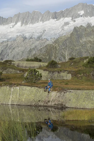 Alpinist está fazendo uma pausa em um lago de montanha no monte suíço — Fotografia de Stock