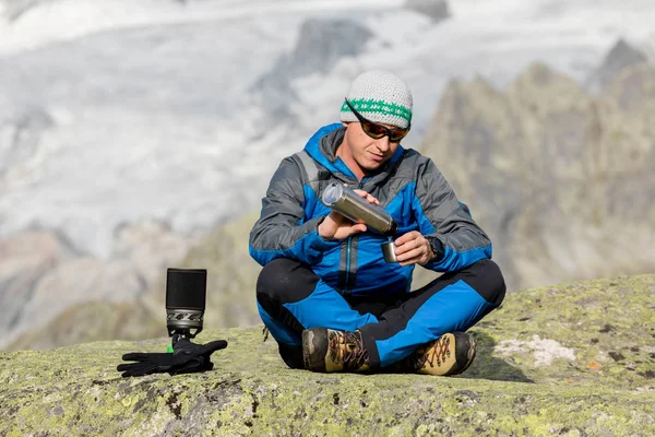 Alpinista faz uma pausa nas montanhas e serve um chá — Fotografia de Stock