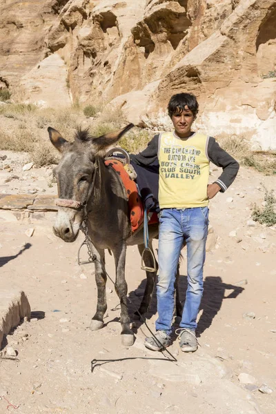 Petra - jordan - 25. Dezember 2015: arabischer Junge mit seinem Esel in — Stockfoto