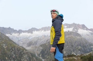 Uzun yürüyüşe çıkan kimse kameraya ciddi bir yüz ifadesiyle görünüyor.