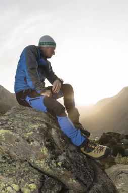 Yakışıklı genç fiyatı bir taşa bir mola ve güneşin doğuşunu sahiptir