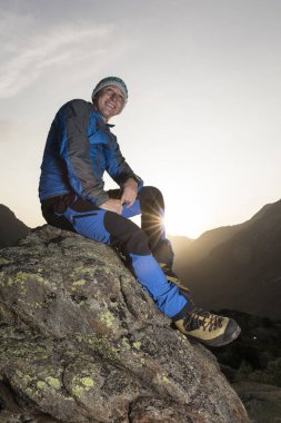 Yakışıklı genç fiyatı bir taşa bir mola ve güneşin doğuşunu sahiptir