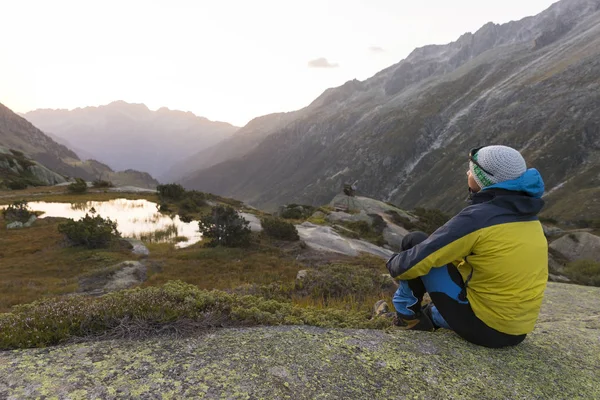 Joven alpinista disfruta de los cálidos rayos de sol después de un estricto recorrido por la montaña —  Fotos de Stock