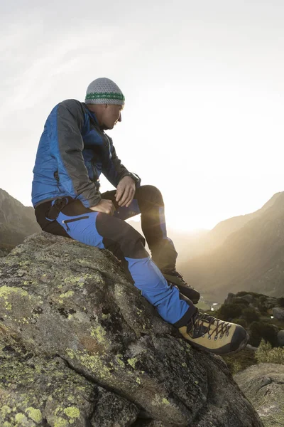 Yakışıklı genç fiyatı bir taşa bir mola ve güneşin doğuşunu sahiptir