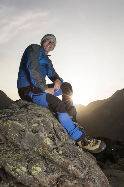 Yakışıklı genç fiyatı bir taşa bir mola ve güneşin doğuşunu sahiptir