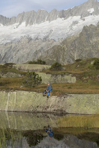 Caminhante faz uma pausa em um lago de montanha nos Alpes na Suíça — Fotografia de Stock