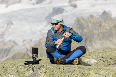 Alpinist nefes kesici dağ manzarasına önce bir çay molası yapar