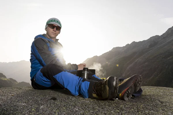 Alpinist duraklar ve sıcak bir içecek, İsviçre hazırlar