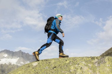 Sportif alpinist İsviçre Alpleri'nde bir dağ zirvesine tırmanıyor