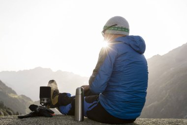 Alpinist İsviçre Alpleri'nde gündoğumu bir mola sırasında sahiptir.