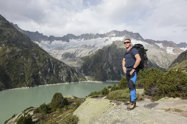 Senderista disfruta de la impresionante vista de un lago de montaña en los Alpes —  Fotos de Stock
