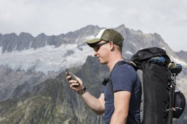 Alpinist arazide bir Gps cihazı ile aydınlatmaktadır
