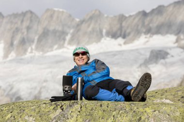 Alpinist nefes kesici dağ manzarasına önce bir çay molası yapar