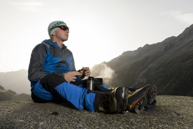 Alpinist duraklar ve sıcak bir içecek, İsviçre hazırlar
