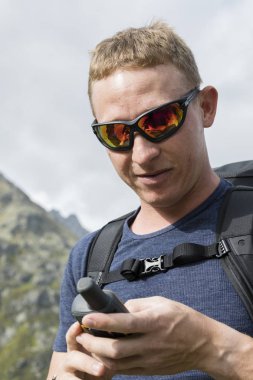 Alpinist arazide bir Gps cihazı ile aydınlatmaktadır