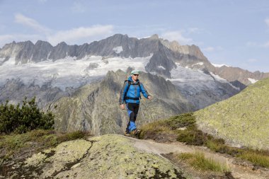 Dağlarda nefes kesen bir Alp peyzaj aracılığıyla uzun yürüyüşe çıkan kimse zamları