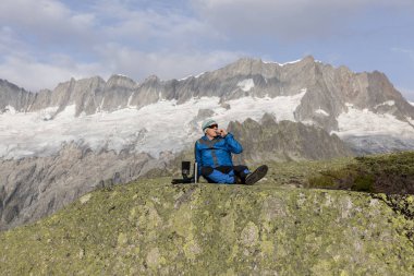 Alpinist nefes kesici dağ manzarasına önce bir çay molası yapar