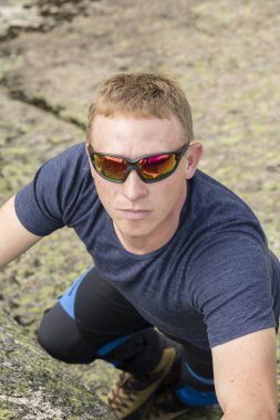 Bir dağcı tırmanma çalışmaları büyük bir kaya üzerinde yapar.