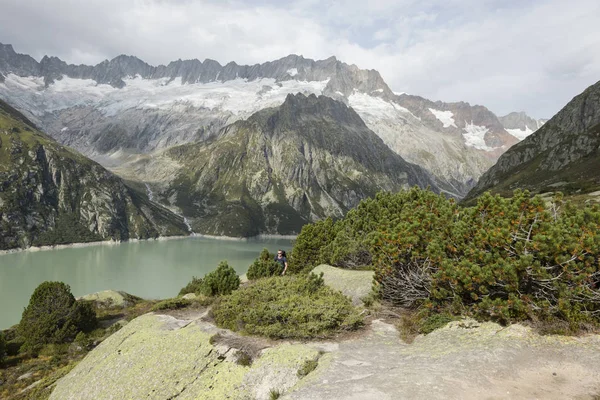 Hiker hikes through the breathtaking mountain scenery in the Swiss Alps — Stock Photo, Image