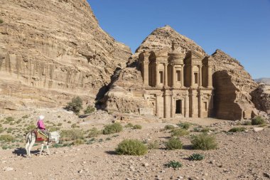 Reklam Deir, Ürdün 25th Aralık 2015: Kız manastır Al Deir: Petra, Jordan önünde bir eşek rides.