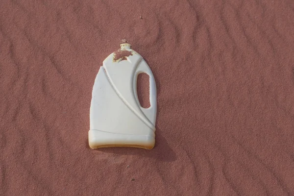 Empty plastic bottle lying in the desert — Stock Photo, Image