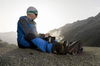Alpinist duraklar ve sıcak bir içecek, İsviçre hazırlar