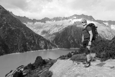 Uzun yürüyüşe çıkan kimse bir dağ gölü İsviçre Alpleri'nde nefes kesen manzarası sahiptir