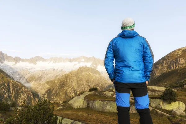 Alpinista se levanta durante el amanecer frente al poderoso paisaje montañoso —  Fotos de Stock