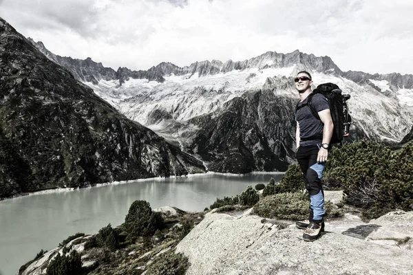 Senderista disfruta de la impresionante vista de un lago de montaña en los Alpes suizos —  Fotos de Stock