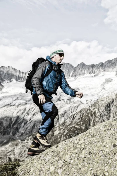 Un alpinista deportivo sube a la cima de una montaña en los Alpes suizos —  Fotos de Stock